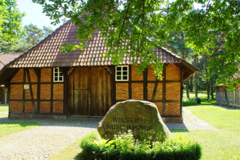 Traditionelles Fachwerkhaus, im Vordergrundeinem Stein graviert mit  "Winsener Museumshof".